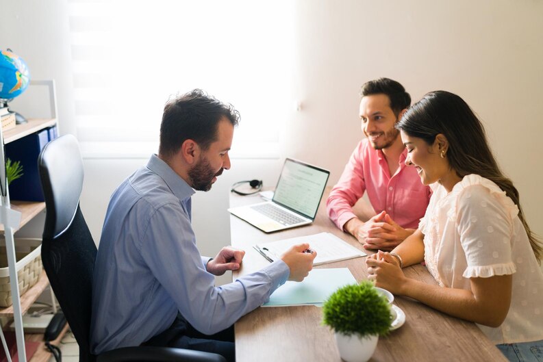 A man and woman collaborate at a desk with a laptop, discussing Group Health Insurance options.jpg